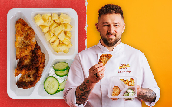 Mężczyzna w kucharskim stroju trzymający tackę z jedzeniem.